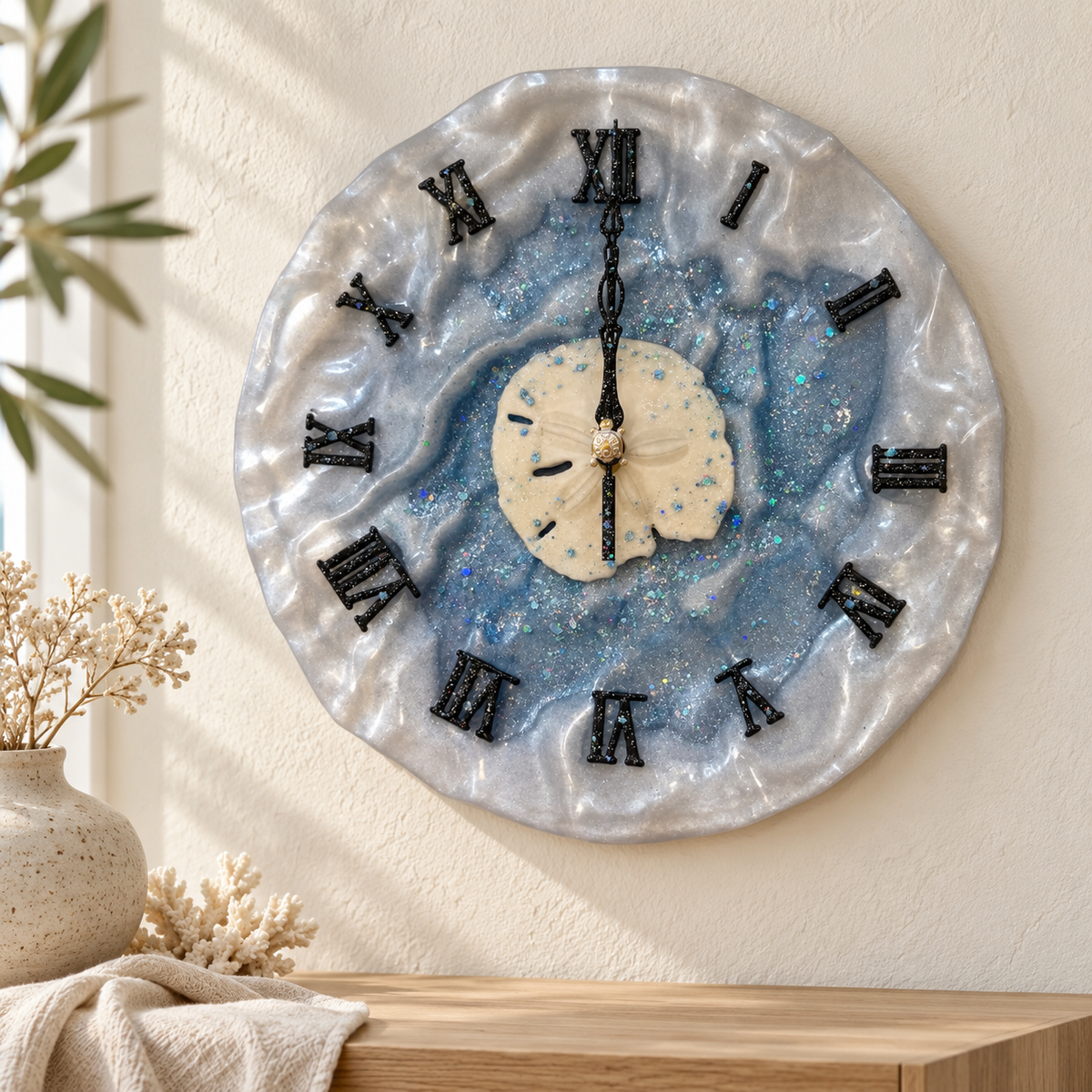 Ocean Shimmer resin wall clock with sand dollar center hanging on a cream wall above a shelf